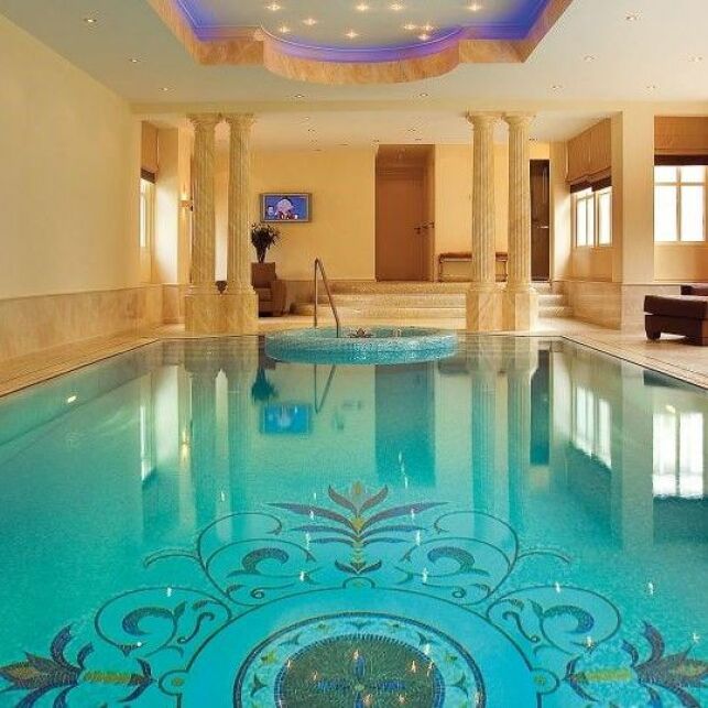 Un espace spa luxueux pour cette piscine avec revêtement en mosaïque fait sur-mesure