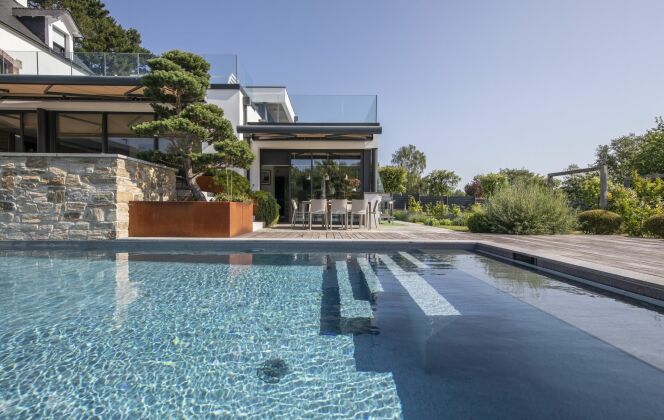 La piscine est dotée d'un escalier droit inversé avec banquette sur la largeur. Architecte paysagiste : “Jardin Breton Design” © DP Piscines / l'esprit piscine - Photo : Fred Pieau. Architecte paysagiste : Jardin Breton Design