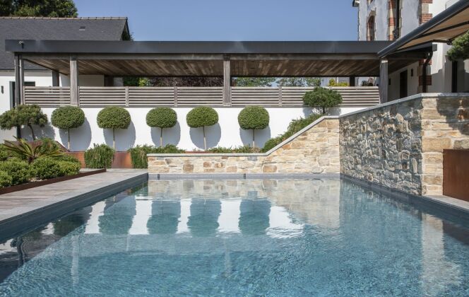 La piscine est intégrée pour créer un véritable espace de détente au bord de cette maison. Architecte paysagiste : “Jardin Breton Design” © DP Piscines / l'esprit piscine - Photo : Fred Pieau. Architecte paysagiste : Jardin Breton Design