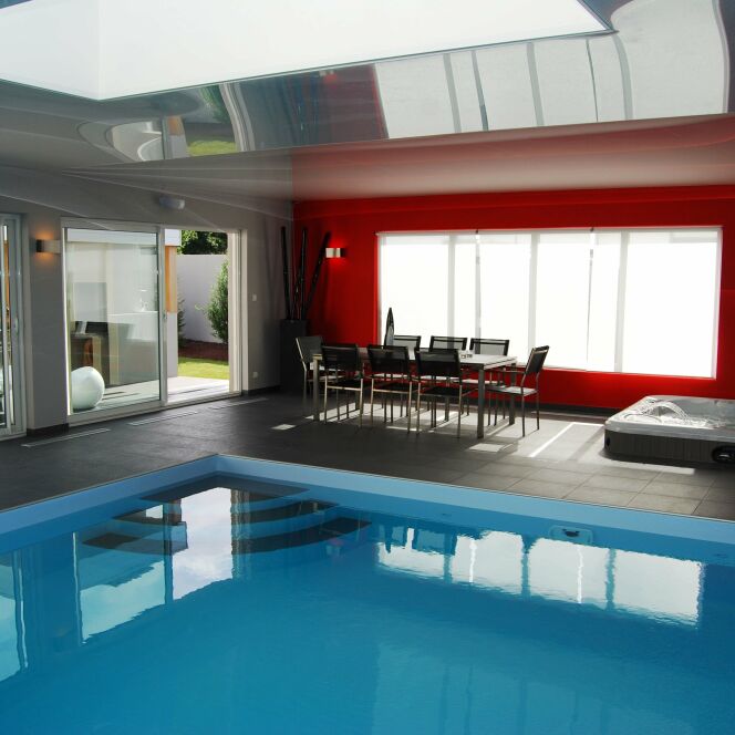 La piscine design intérieure fait partie du salon © L'Esprit Piscine