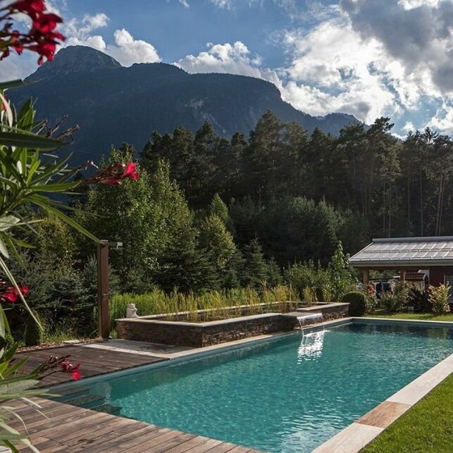 Une piscine avec une terrasse en bois, à la fois naturelle et moderne