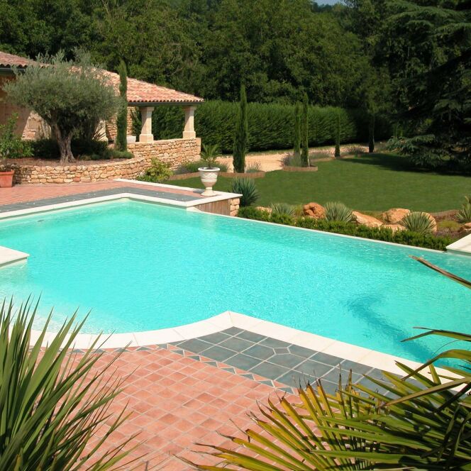 Maison provençale avec piscine à débordement et escalier arrondi  © L'Esprit Piscine