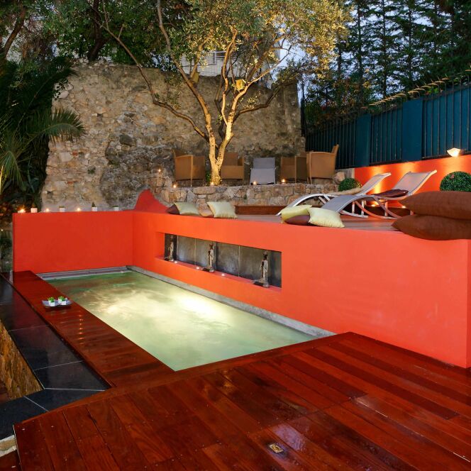 Mélange des matériaux bruits et couleurs chaudes autour d'une piscine design savamment éclairée © L'Esprit Piscine