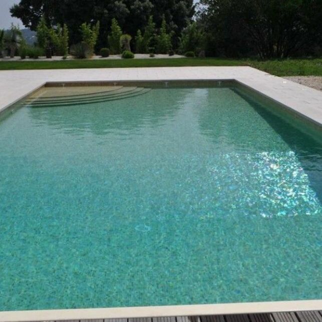 Une piscine avec revêtement mosaïque sable pour une couleur d'eau turquoise
