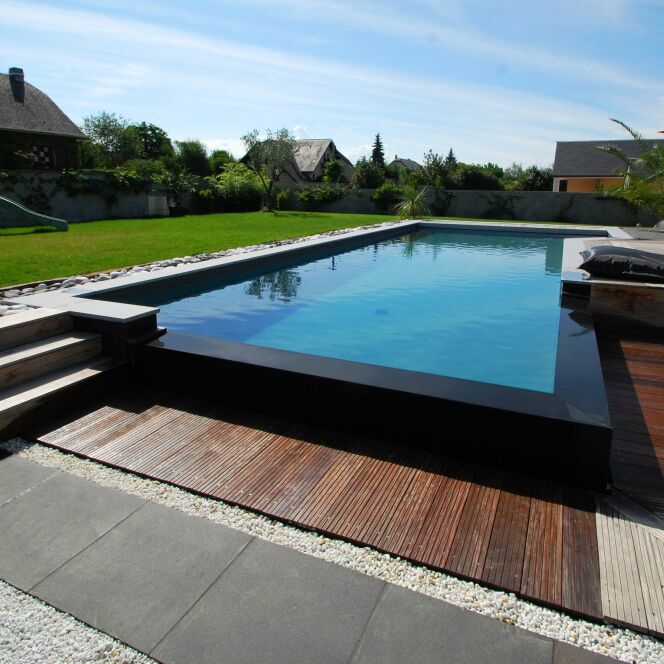 Piscine à débordement design avec bordure noire et terrasse en bois © L'Esprit Piscine