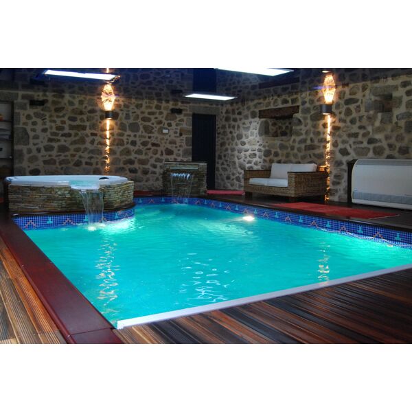 piscine_interieure_bordee_de_mosaique_avec_spa_a_debordement_murs_de_pierre_et_plages_en_bois 3267 600 600 F