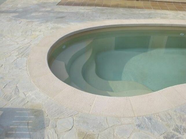 Cette piscine coque en forme de haricot offre une belle surface de nage.
