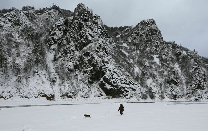 Un homme promène son chien au bord du fleuve © REUTERS/ ILYA NAYMUSHIN