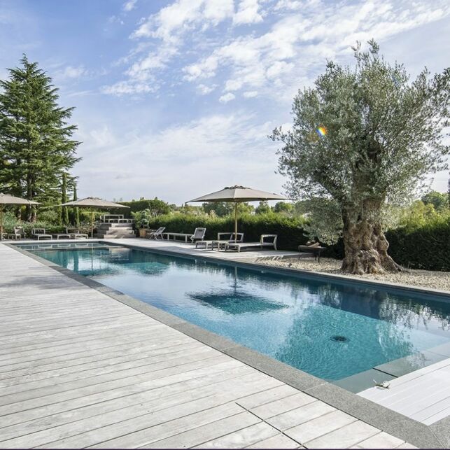 Une piscine rénovée moderne sur une terrasse en bois grisé